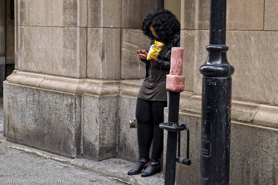 Girl with phone texting on the street